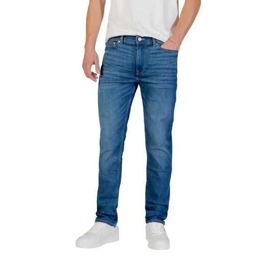 Blue denim jeans with a slim fit and white sneakers.