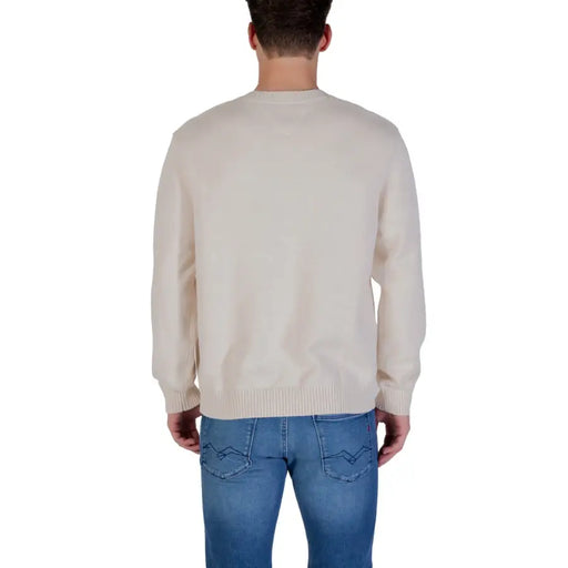 Cream-colored crew neck sweater with ribbed cuffs and hem, likely made of cotton or wool.
