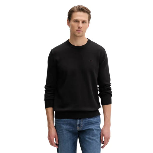 Pull noir Tommy Hilfiger à col rond, poignets et ourlet côtelés, en maille de coton biologique.