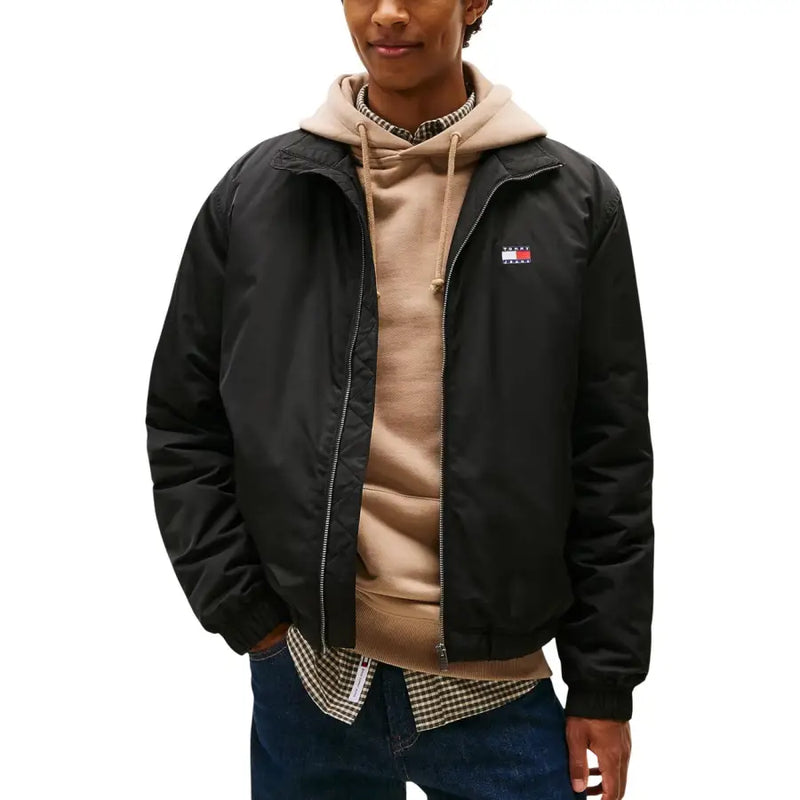 Blouson aviateur noir Tommy Hilfiger en polyester, zippé, avec petit logo drapeau rouge, blanc et bleu sur la poitrine gauche.