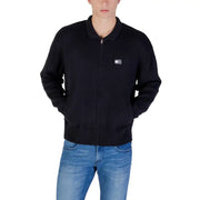 Black zip-up bomber jacket with small logo on chest, made of cotton and polyester blend.