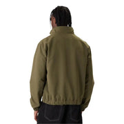 Veste Carhartt vert olive à col montant et poignets élastiqués, présentée avec un jean Tommy Hilfiger et un blazer vert à fermeture éclair longue en polyester.