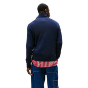 Navy blue turtleneck sweater with ribbed cuffs and hem layered over red and white striped shirt in Tommy Hilfiger sweatshirt