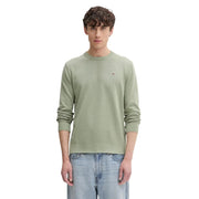 A men’s olive green organic cotton knit sweater by Tommy Hilfiger Jeans with ribbed cuffs and an embroidered logo