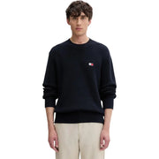 Pull homme Tommy Hilfiger Jeans bleu marine en maille côtelée, en coton biologique, avec logo drapeau brodé sur la poitrine gauche.