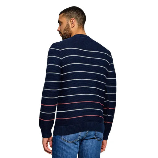 Tommy Hilfiger Jeans Pull en maille de coton biologique bleu marine à rayures, avec rayures horizontales blanches et rouges et poignets côtelés.