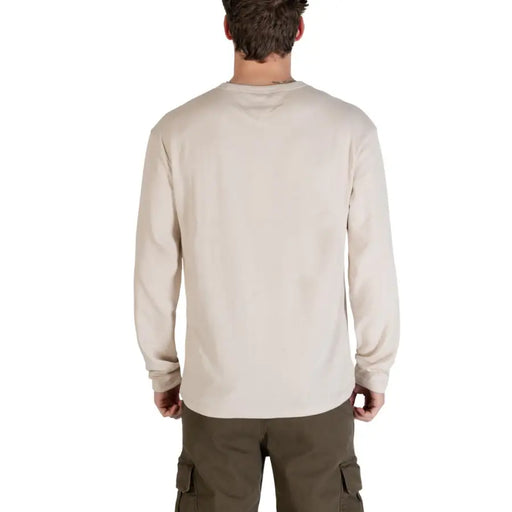 Tommy Hilfiger Jeans T-shirt homme beige en coton bio, manches longues, col rond, tissu texturé doux et délavage subtil aux épaules.