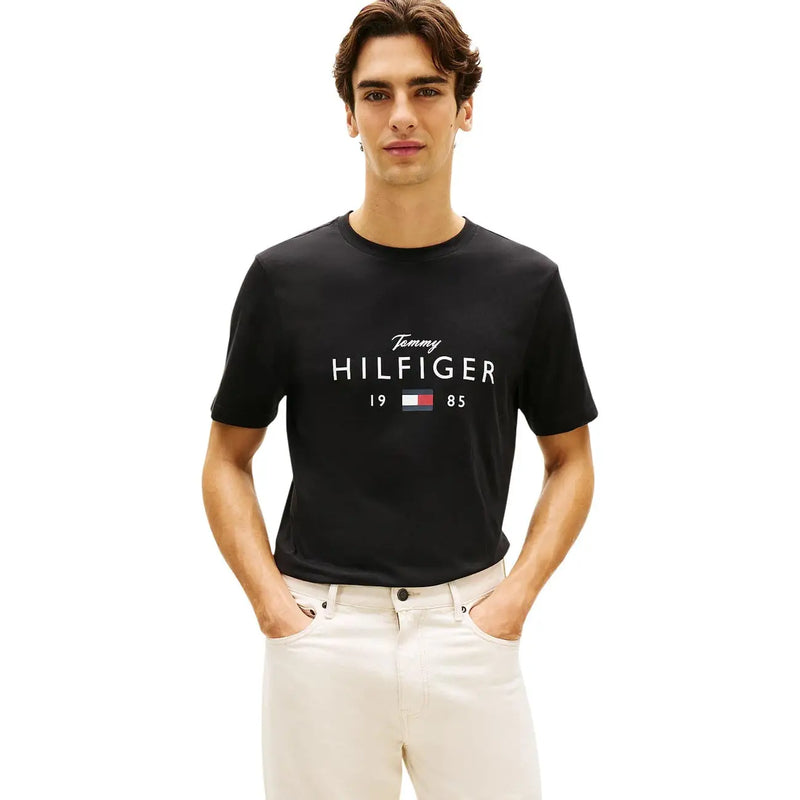 T-shirt homme Tommy Hilfiger Jeans en coton noir, orné du logo Tommy Hilfiger 1985 blanc et de l'emblème de la marque.
