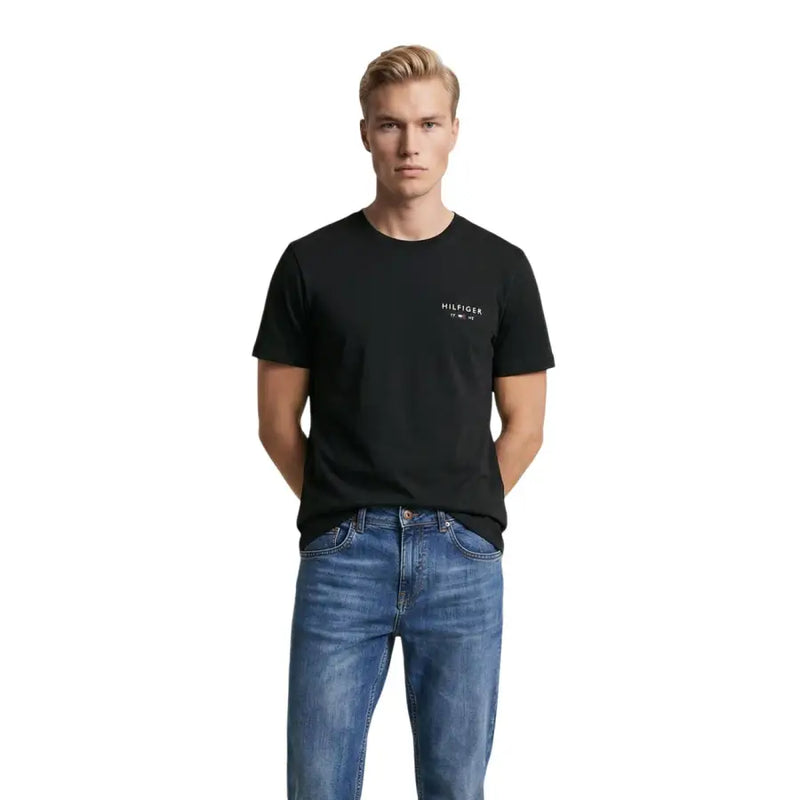 Tommy Hilfiger T-shirt noir en coton pour homme avec un logo blanc discret sur la poitrine gauche et un col rond.