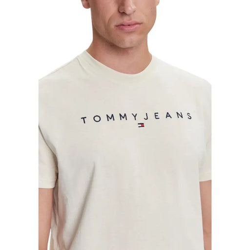 couleur crème Tommy Hilfiger Jeans hommes t-shirt avec le lettrage noir Tommy Jeans et un petit logo drapeau en dessous.