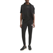 Pantalon de jogging Tommy Hilfiger Jeans noir pour homme, avec petit logo blanc et rouge sur la cuisse gauche.