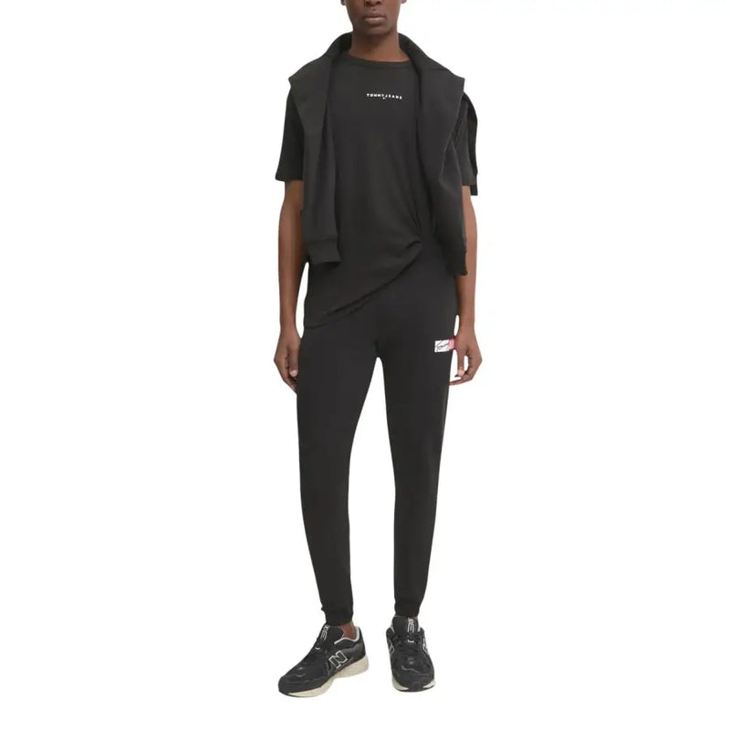 Pantalon de jogging Tommy Hilfiger Jeans noir pour homme, avec petit logo blanc et rouge sur la cuisse gauche.
