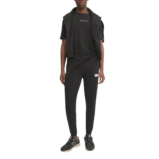 Pantalon de jogging Tommy Hilfiger Jeans noir pour homme, avec petit logo blanc et rouge sur la cuisse gauche.
