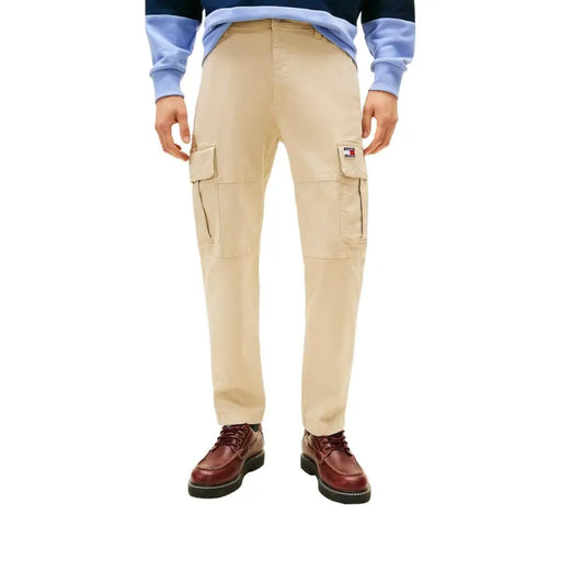 Pantalon cargo beige Tommy Hilfiger pour homme, avec de multiples poches et un écusson logo sur la cuisse.