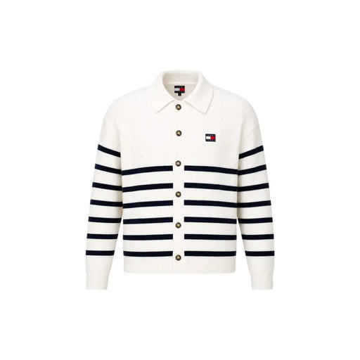 Un cardigan en maille couleur crème à rayures bleu marine et fermeture boutonnée, porté avec un sweat-shirt blanc en coton bio Tommy Hilfiger Jeans pour homme