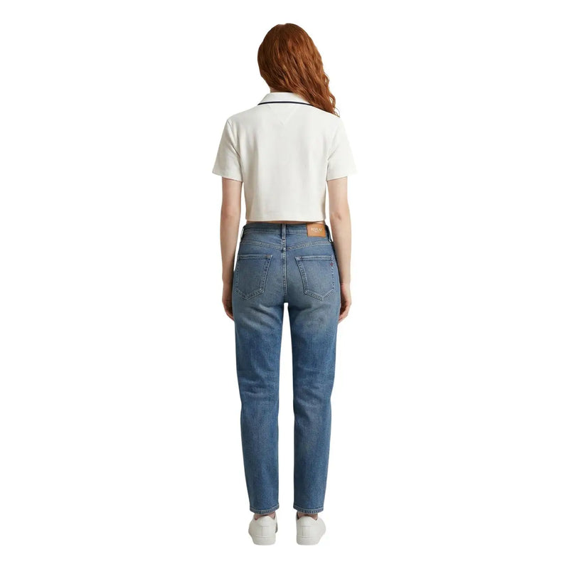 Un jean Tommy Hilfiger en denim bleu moyen, coupe droite, avec un empiècement en cuir marron à la ceinture.