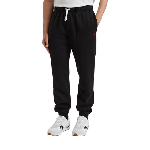 Pantalon polaire noir Tommy Hilfiger pour homme, mélange de coton avec cordon de serrage blanc et logo discret sur la cuisse (vue de face)
