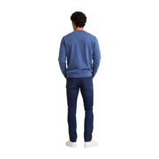 Un homme portant un Tommy Hilfiger Sweat-shirt bleu en coton à col rond pour homme, porté avec un jean en denim foncé.