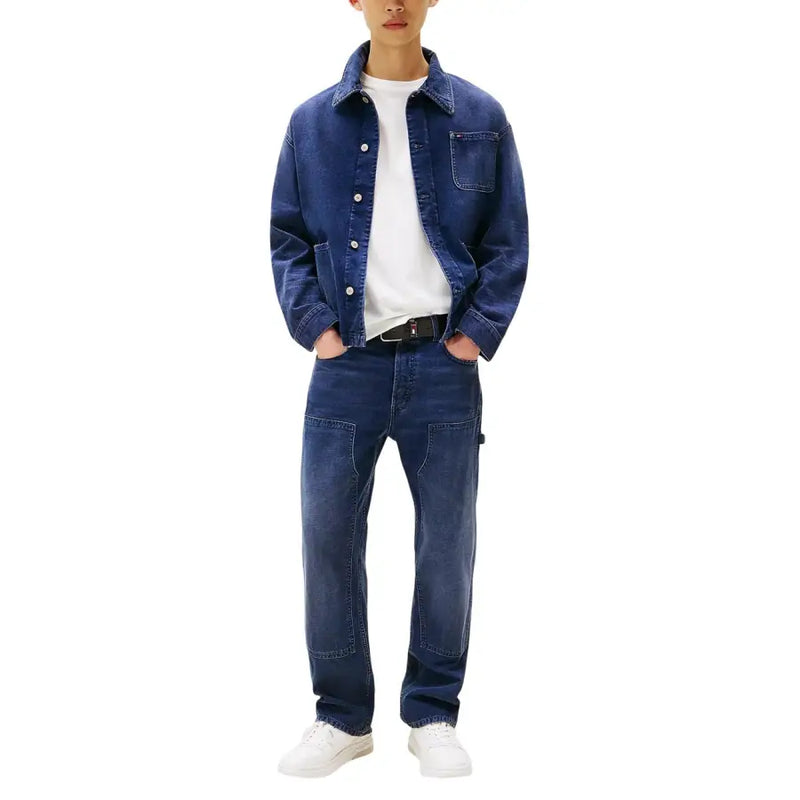 Jean Tommy Hilfiger pour homme en coton biologique bleu, porté avec une veste en jean bleu foncé à boutons et poche poitrine.