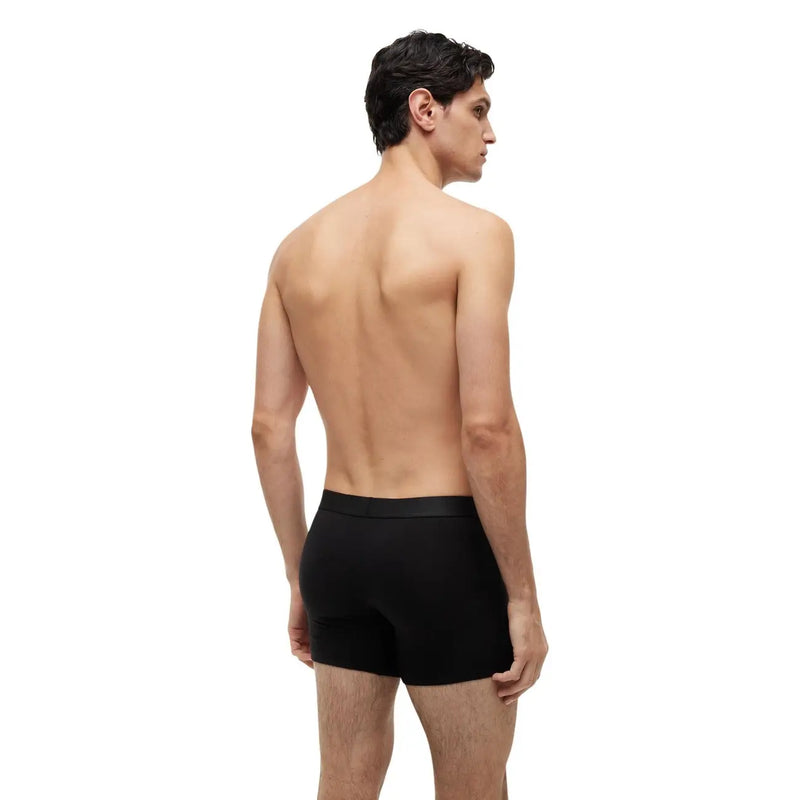 Black calvin klein boxer briefs with a smooth form-fitting design shown from the back in tommy hilfiger black organic cotton