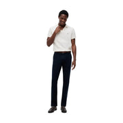 Un homme vêtu d'un blanc éclatant Tommy Hilfiger Polo en coton porté avec un pantalon en coton bleu coupe Denton