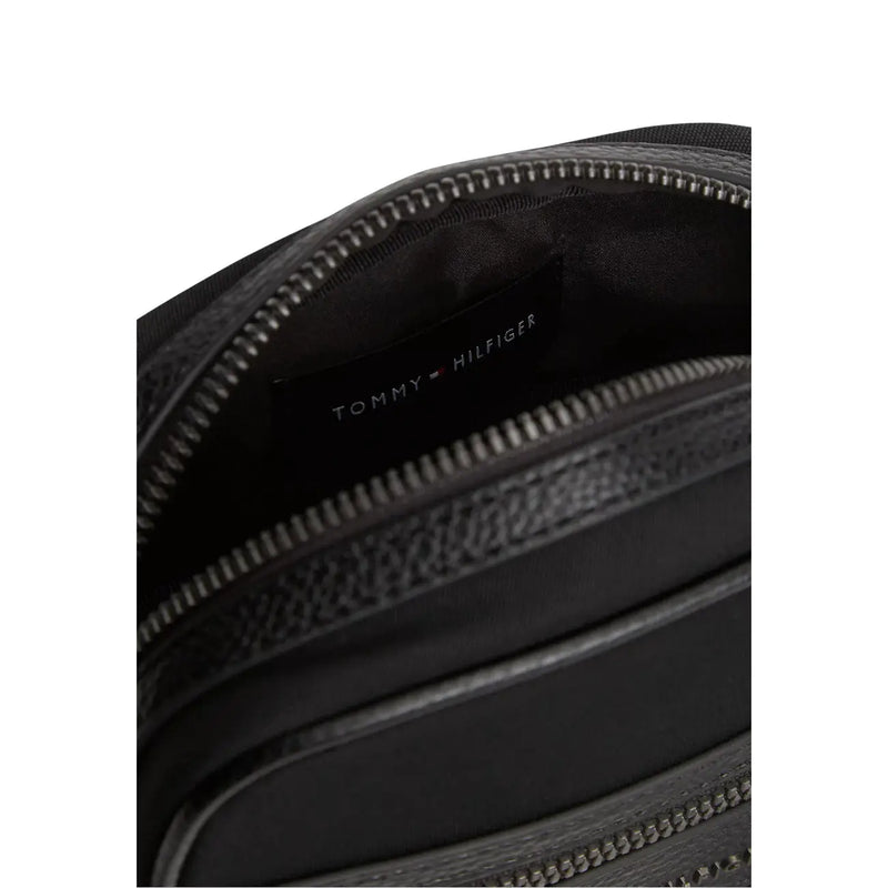 Tommy Hilfiger Sac de reporter miniature pour homme en similicuir noir texturé avec fermeture éclair argentée.