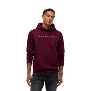 Sweat à capuche marron Tommy Hilfiger pour homme avec logo blanc et poche avant associé à un t-shirt vert en coton biologique coupe régulière