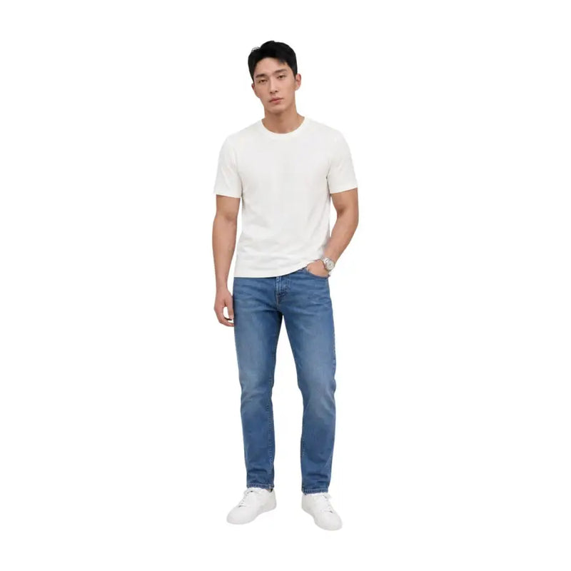 Un jean Tommy Hilfiger pour homme, modèle Austin Slim fuselé, en coton bleu délavé moyen et coupe classique à cinq poches.
