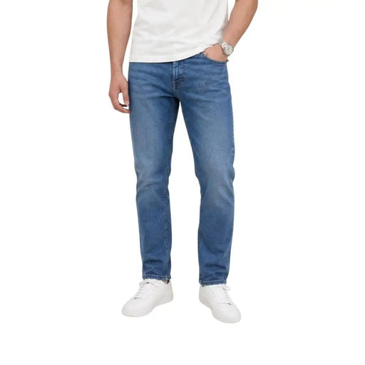 Jean en denim de coton bleu moyen pour homme, coupe slim fuselée et design classique à cinq poches. Tommy Hilfiger