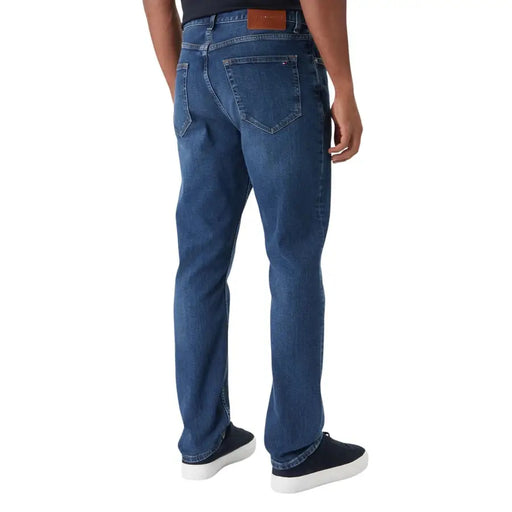 Jean Tommy Hilfiger pour homme en coton biologique bleu, coupe slim, avec un design classique à cinq poches et un écusson de la marque en cuir marron.