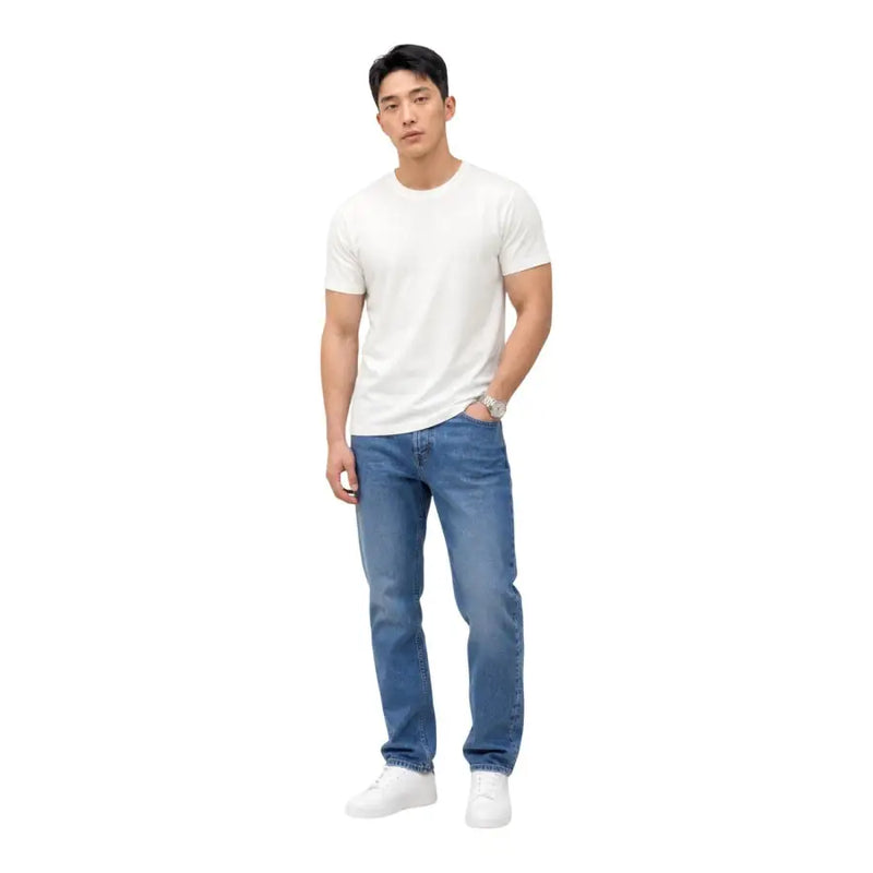 Un homme portant Tommy Hilfiger Jean slim bleu en coton bio avec un t-shirt blanc uni à manches courtes t-shirt