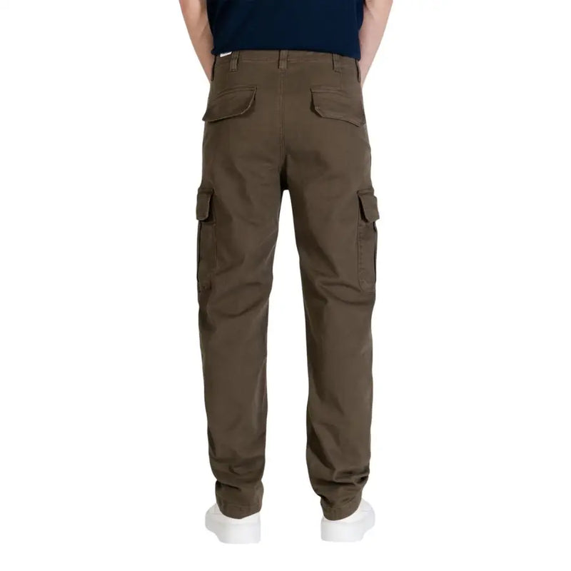 Pantalon cargo marron à poches multiples et tissu résistant, porté avec un jean Tommy Hilfiger pour homme et un pantalon vert en coton bio.