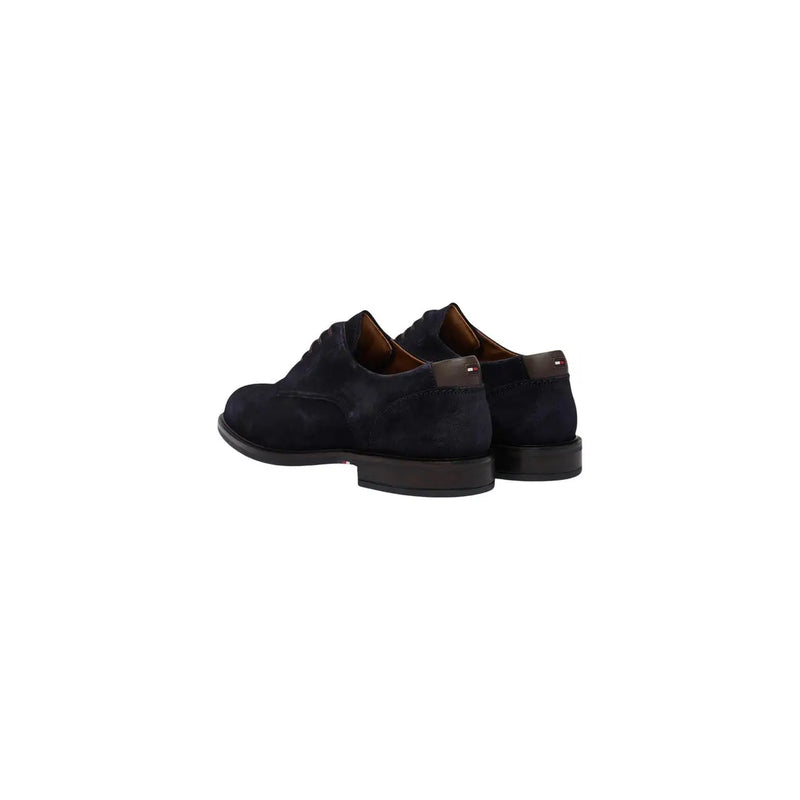 Chaussures Oxford Tommy Hilfiger pour homme en daim bleu marine, semelles en caoutchouc noir et logo rouge, blanc et bleu sur la languette arrière.