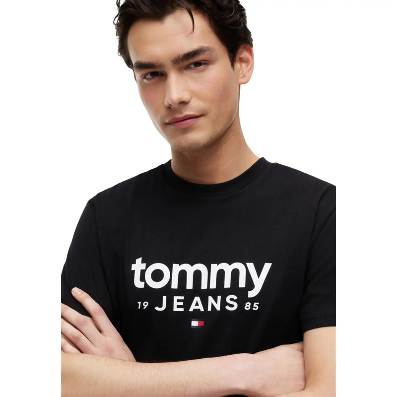 Tommy Hilfiger T-shirt noir en coton biologique pour homme, orné du logo Tommy 19 Jeans 85 et d'un drapeau blanc sur le devant.