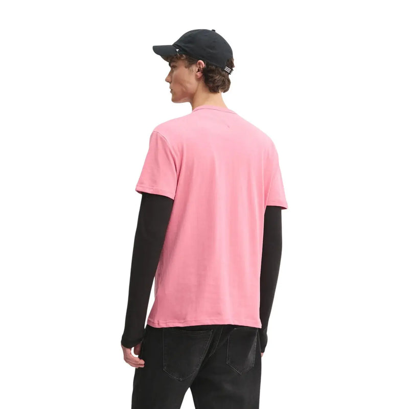 Tommy Hilfiger T-shirt rose en coton bio pour homme, coupe classique, à porter sur une chemise noire à manches longues.
