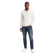 Pull polo Tommy Hilfiger couleur crème, à col classique et fermeture boutonnée, porté avec un jean slim bleu en coton