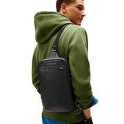 Sac bandoulière Tommy Hilfiger pour homme, noir, en polyuréthane, avec motif tissé texturé, design minimaliste et élégant, dimensions : 24 x 33 x 9 cm.