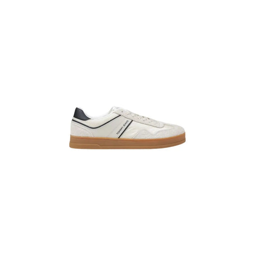 Baskets Tommy Hilfiger blanches pour homme en cuir avec détails noirs et semelle en caoutchouc beige, parfaites pour un style décontracté.