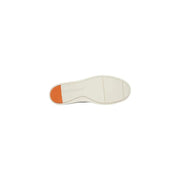 Semelle en caoutchouc blanc et languette orange vif au talon, visibles à l'arrière des mocassins en daim camel pour homme Tommy Hilfiger.