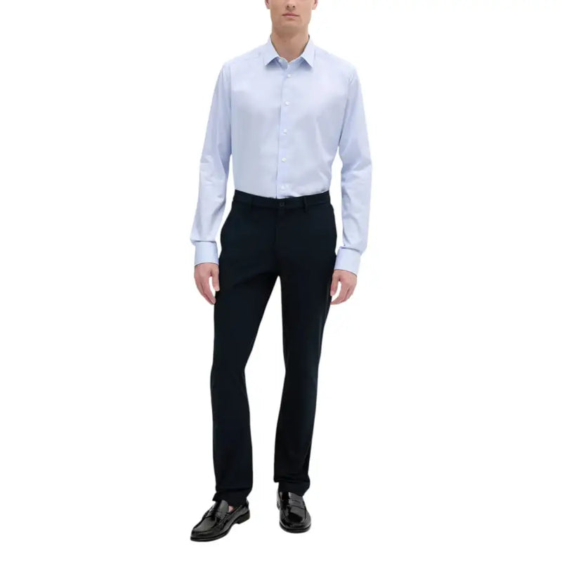 Chemise habillée bleu clair à col classique et fermeture boutonnée, portée avec un pantalon Tommy Hilfiger pour homme