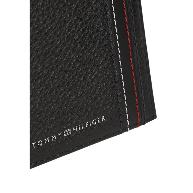 Tommy Hilfiger Portefeuille homme en cuir noir texturé avec surpiqûres contrastantes rouges, blanches et bleu marine.
