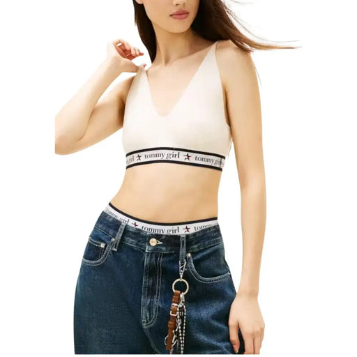 Cream-colored tommy girl bralette with black elastic band and star logo paired with tommy hilfiger white sleeveless v neck knit top for women