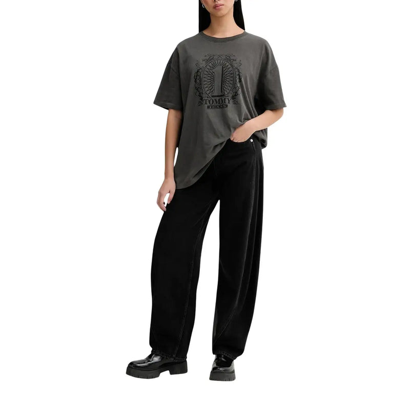 Un gris foncé surdimensionné t-shirt avec logo brodé noir porté par le mannequin associé à Tommy Hilfiger jean noir en coton bio
