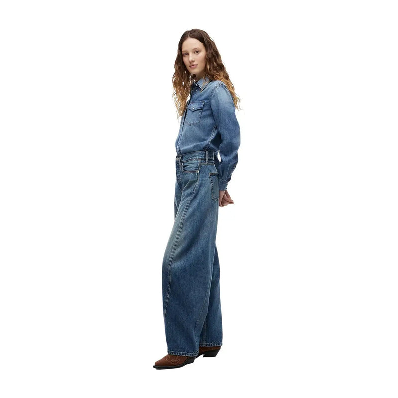 Une femme portant un jean Tommy Hilfiger bleu marine, coupe mi-mollet, jambes larges et délavage bleu délavé.