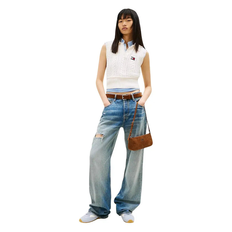 Sac bandoulière en daim marron au design minimaliste et logo discret, porté avec un jean Tommy Hilfiger pour femme en denim bleu clair et coton biologique.