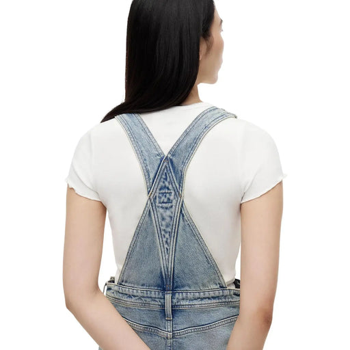 Jupe en jean Tommy Hilfiger pour femme, en coton bio bleu, présentée avec une salopette en jean délavé clair et un dos croisé.