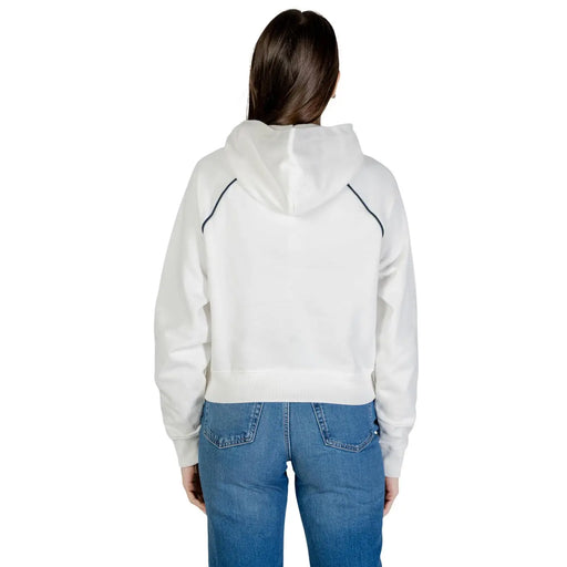 Tommy Hilfiger Sweat à capuche court blanc en coton biologique pour femme, avec surpiqûres noires contrastantes sur les manches et le bord de la capuche.
