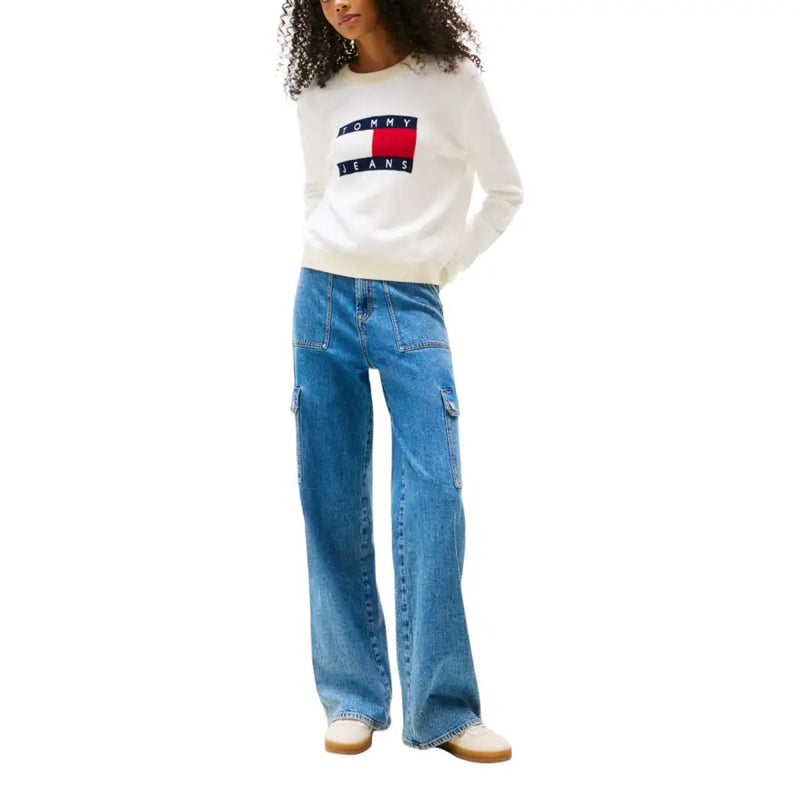 Women wearing white Tommy Hilfiger long-sleeve sweatshirt and blue cargo jeans