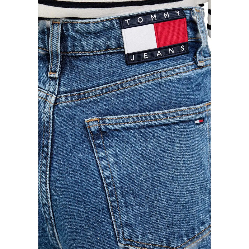 Jean large en denim bleu Tommy Hilfiger pour femme, orné d'un écusson classique de la marque avec un motif drapeau rouge, blanc et bleu marine.