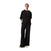 Coton noir Tommy Hilfiger pantalon de survêtement à jambes larges pour femme, associé à un sweat-shirt à capuche noir avec un petit logo blanc